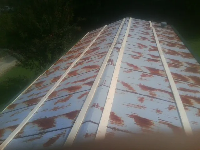 Rusted metal roof panels with new wood purlins before replacement — Storm Damage Roof Repair in Canon City by Roofing Brothers