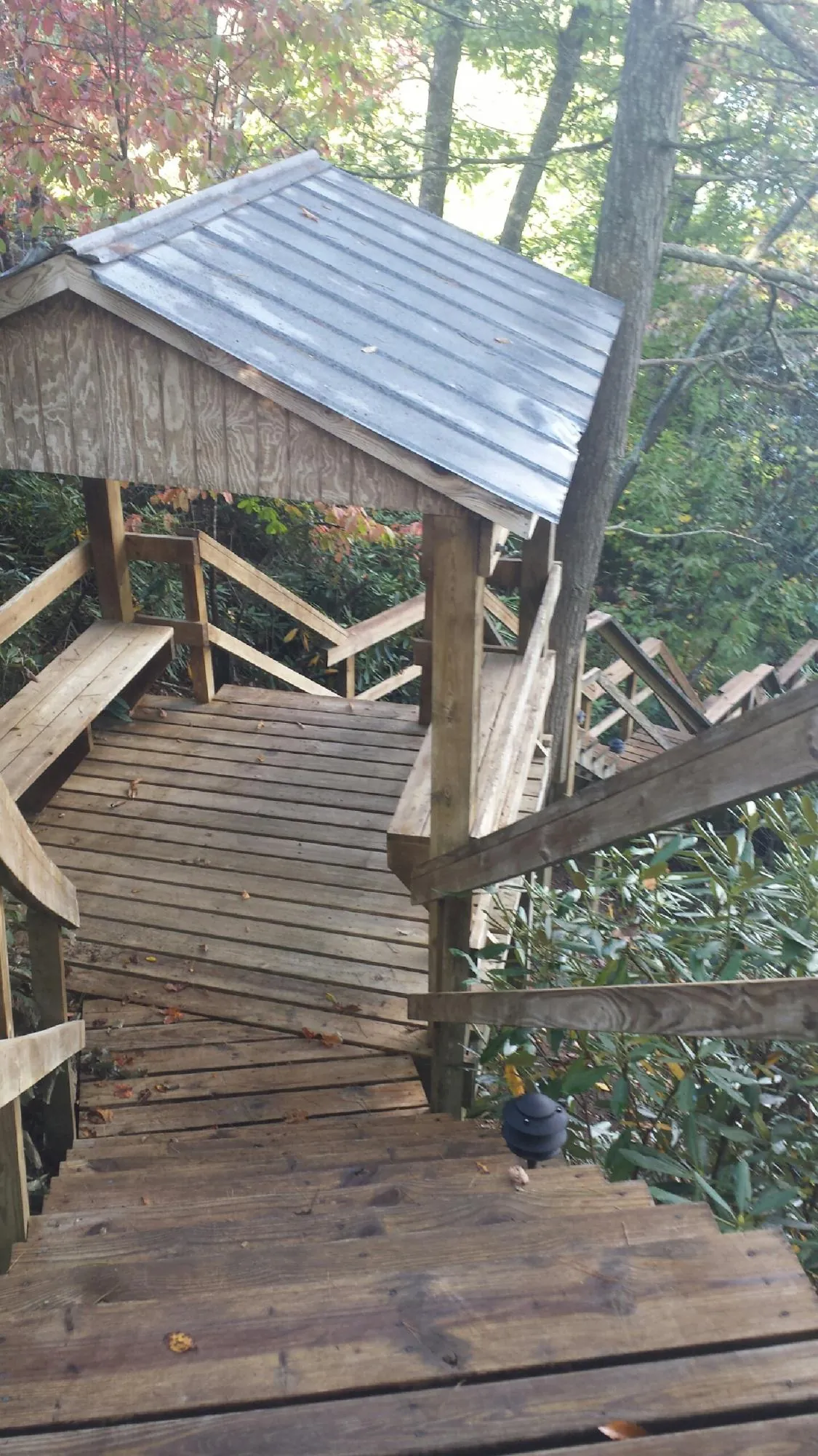 Metal roofed shelter over wooden steps on a wooded walkway — Skylight Repair & Installation work by our crew in Canon City